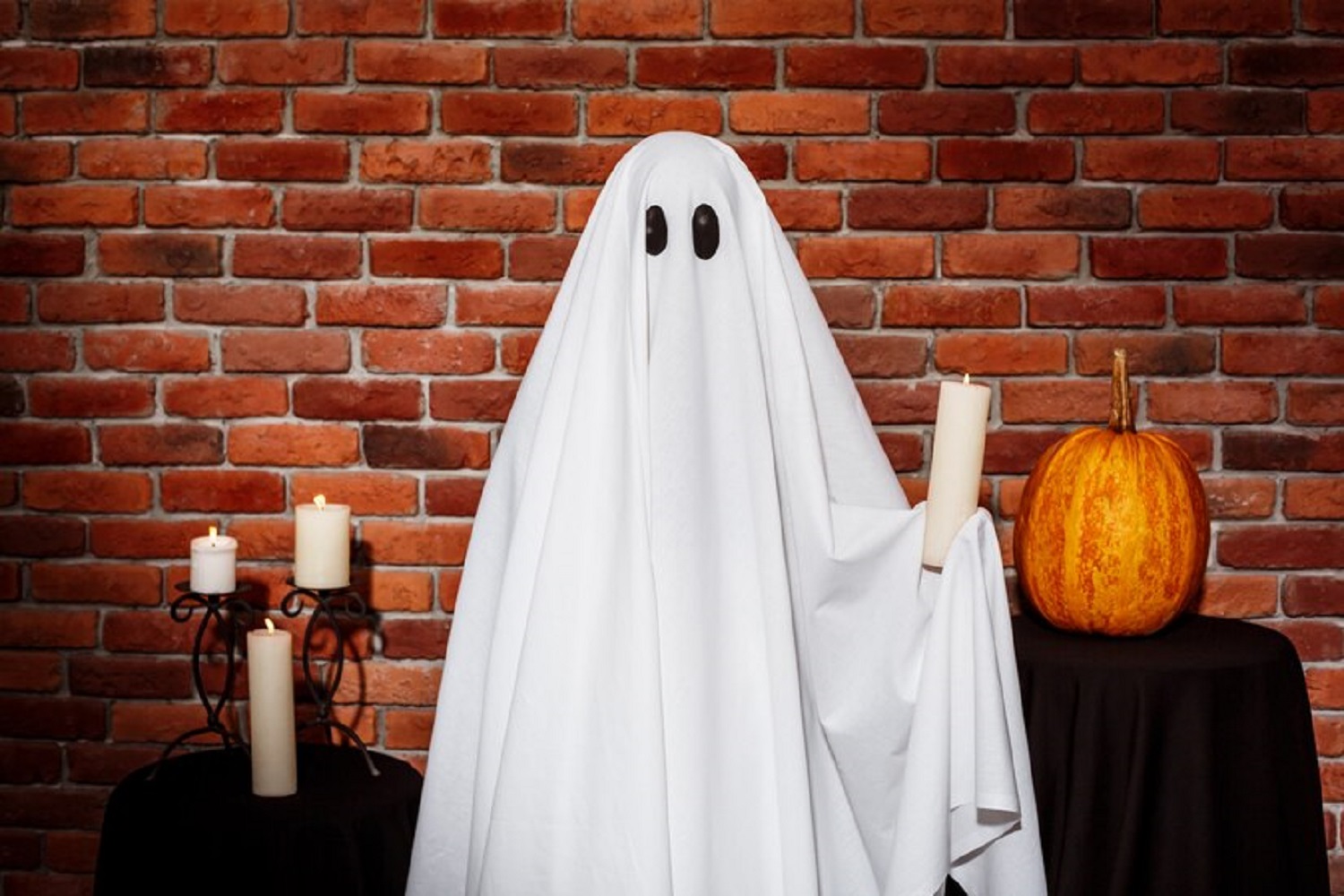 ghost-holding-candle-brick-wall-halloween-party_176420-8381
